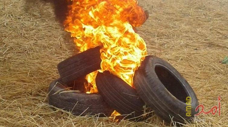 بالصور.. شبان يشعلون إطارات الكوشوك لحماية المتظاهرين شرق خانيونس